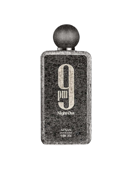 A rectangular perfume bottle with a textured dark gray and black stone-like finish, featuring a spherical black cap. The front label displays '9 pm Night Out' in distressed white typography, with 'AFNAN' and 'eau de parfum' printed below.