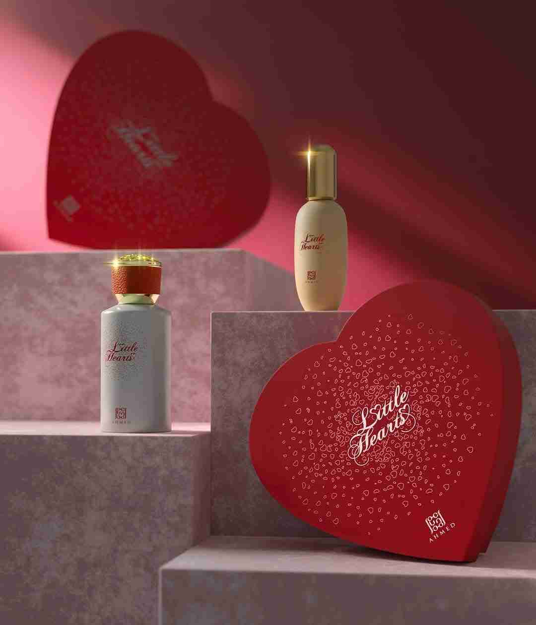 Two perfume bottles and a heart-shaped box with 'L'oreille Fleurie' branding on a pink background.