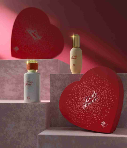 Two perfume bottles and a heart-shaped box with 'L'oreille Fleurie' branding on a pink background.