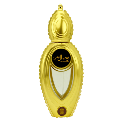 A gold-colored perfume bottle with a sculpted, ribbed cap and body, featuring a black oval label with gold Arabic calligraphy and the text 'Ajmal Wisal Dhahab '. The bottle is centered on a plain white background.
