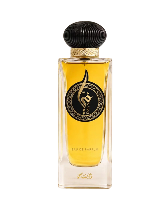 A rectangular glass perfume bottle filled with golden-yellow fragrance, featuring a black ribbed cap with a gold band and a black circular label with Arabic calligraphy. The text 'EAU DE PARFUM' is visible near the bottom, and the brand name 'SABZ' is printed vertically inside the label.
