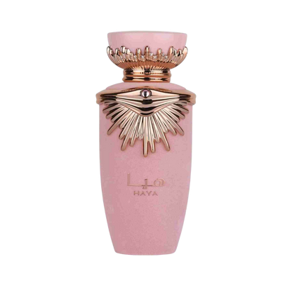A pink cylindrical perfume bottle with a metallic rose gold crown cap and sunburst emblem on the front, featuring the brand name HAYA.